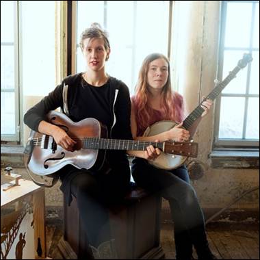 Two women holding musical instruments
Description automatically generated