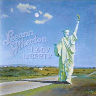 A statue of liberty on a road
Description automatically generated