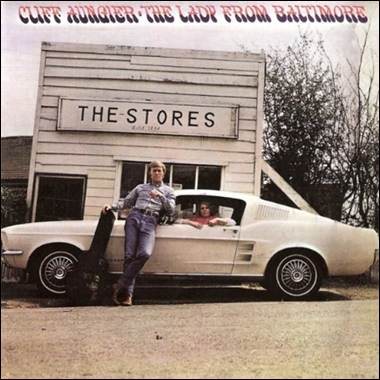 A person leaning on a car with a skateboard in the back
Description automatically generated