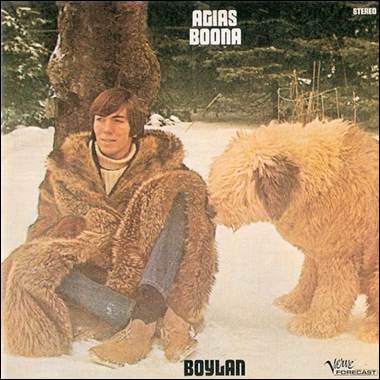 A person sitting in the snow next to a dog
Description automatically generated