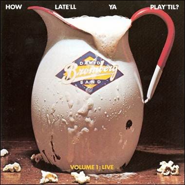 A pitcher of milk with a red handle
Description automatically generated