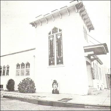 A white building with a face on the side

Description automatically generated