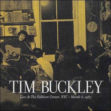 A person playing guitar in a room with a crowd of people
Description automatically generated