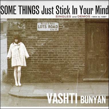 A person standing in front of a brick building
Description automatically generated