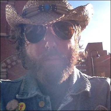 A person wearing a cowboy hat and sunglasses
Description automatically generated