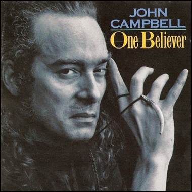 A person with long hair holding his hand up
Description automatically generated