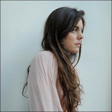 A person with long hair looking away
Description automatically generated