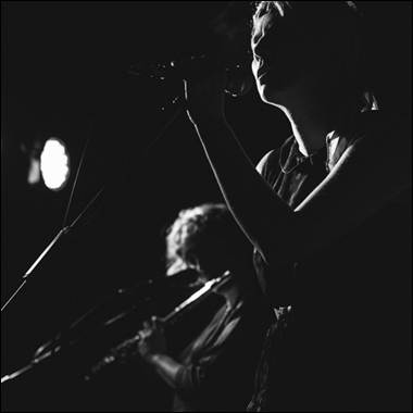 A person singing into a microphone
Description automatically generated