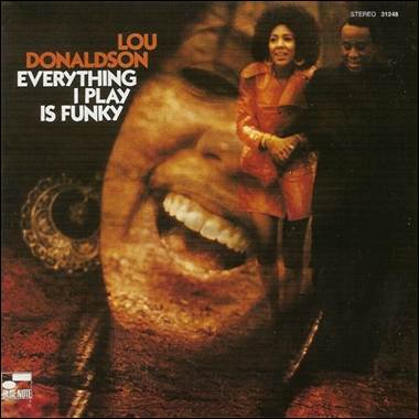 A person and person standing in front of a large face
Description automatically generated