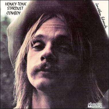 A person with long hair and a cowboy hat
Description automatically generated