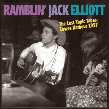 A person playing guitar with a person in the background

Description automatically generated