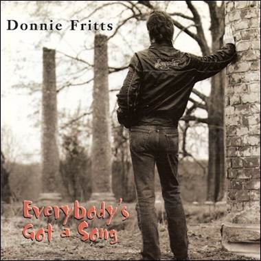 A person standing next to a brick wall
Description automatically generated