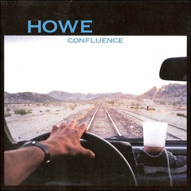 A hand on the steering wheel of a car
Description automatically generated