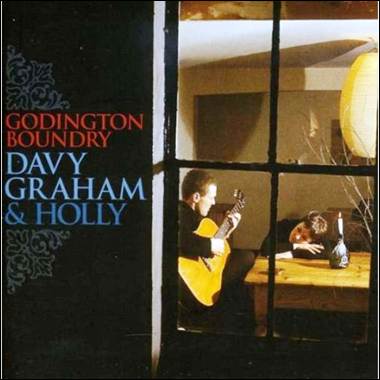 A person playing guitar in front of a window
Description automatically generated