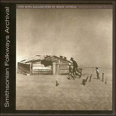 A person and child outside a wooden house

Description automatically generated