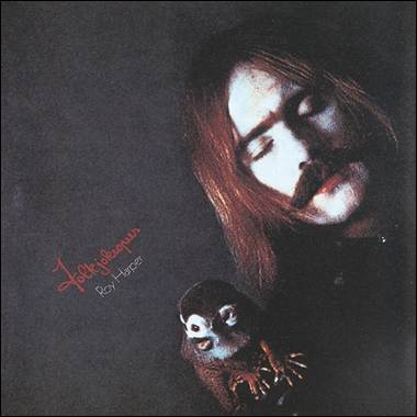 A person with long hair and mustache holding a small owl
Description automatically generated