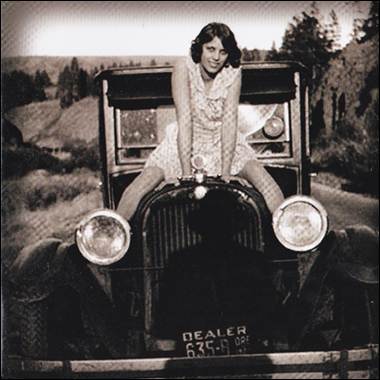 A person sitting on the hood of a car
Description automatically generated