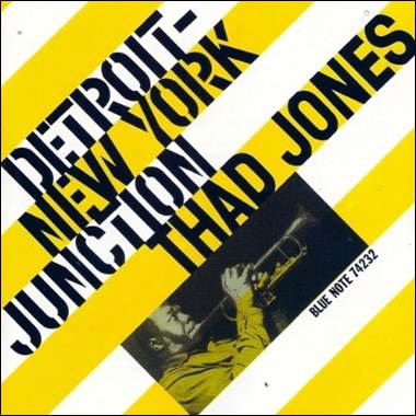 A yellow and white striped cover with a person holding a trumpet
Description automatically generated