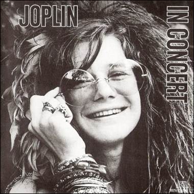 A person smiling with glasses and feathers
Description automatically generated