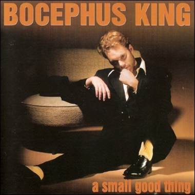 A person in a suit sitting on a chair
Description automatically generated