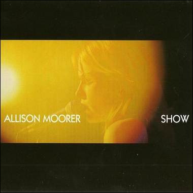 A person singing into a microphone
Description automatically generated