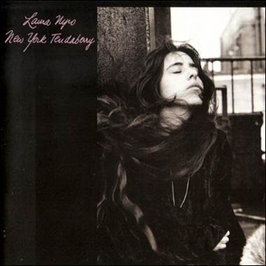 A person with long hair leaning against a wall
Description automatically generated