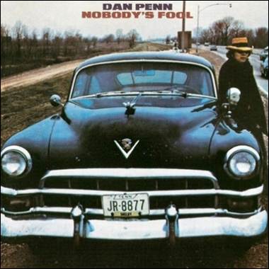 A person standing in front of a car
Description automatically generated