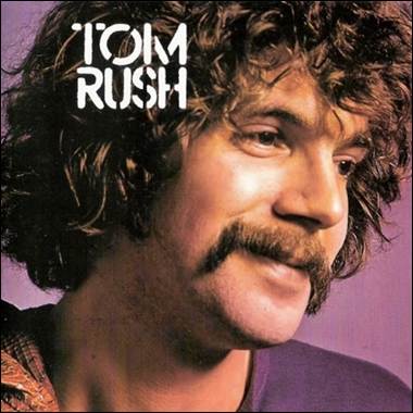 A person with curly hair and a mustache

Description automatically generated