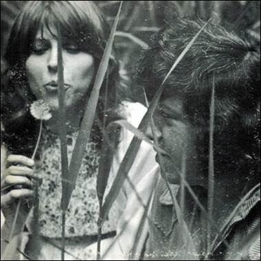 A person and person blowing a dandelion
Description automatically generated