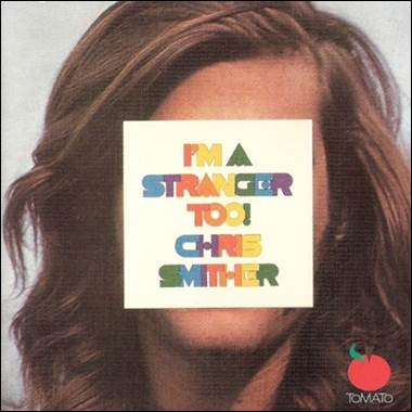 A person with long hair covering his face with a white square with colorful text
Description automatically generated