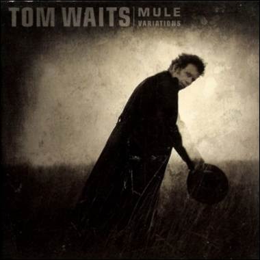 A person in a black cape holding a hat
Description automatically generated