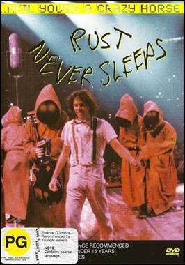 A person standing on a stage with a group of people in the back

Description automatically generated