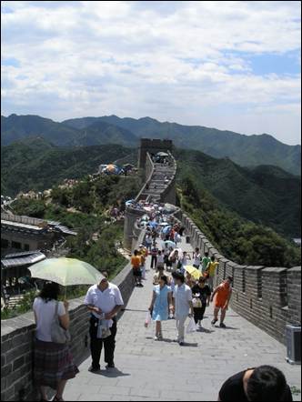 A group of people walking on a long wall with Badaling in the background

AI-generated content may be incorrect.