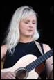 A person with white hair playing a guitar

Description automatically generated