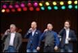 A group of men singing on stage

Description automatically generated