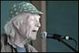 An old person with a green hat singing into a microphone

Description automatically generated with low confidence